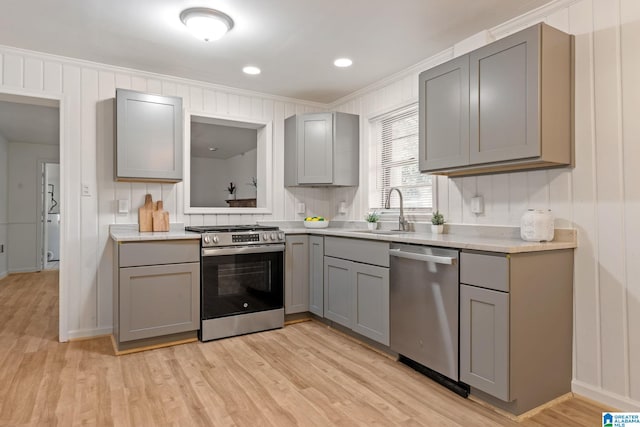 kitchen featuring gray cabinets, ornamental molding, sink, and appliances with stainless steel finishes