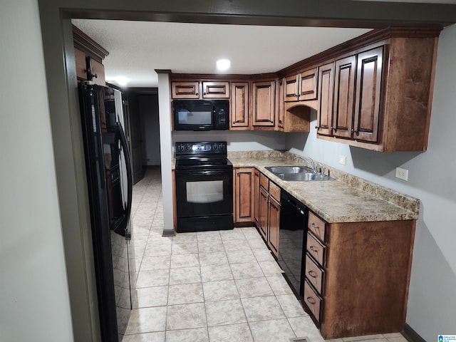 kitchen featuring black appliances, sink, and light tile patterned floors