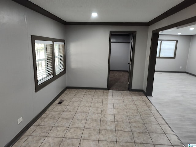 unfurnished bedroom featuring crown molding, a textured ceiling, and multiple windows