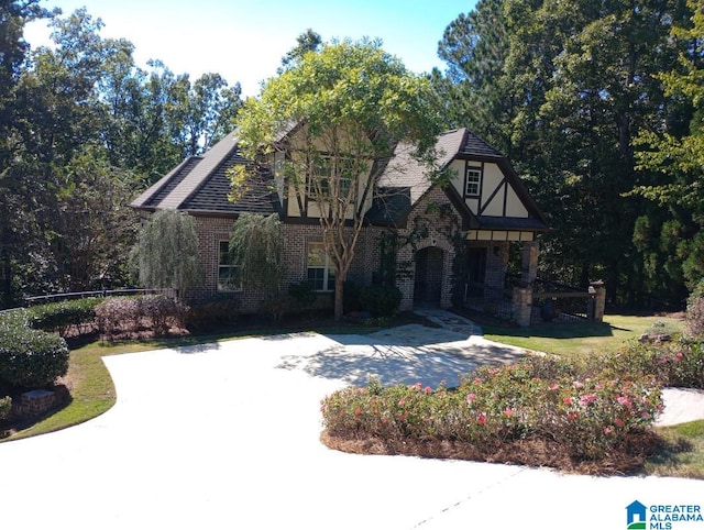 tudor-style house featuring a front yard