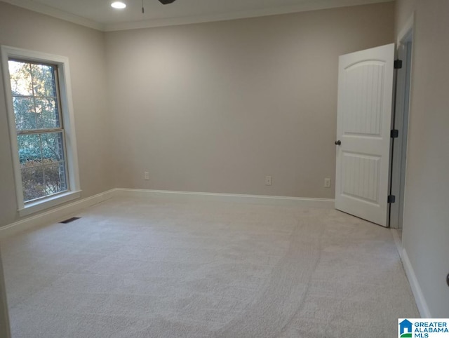 carpeted spare room featuring crown molding and ceiling fan