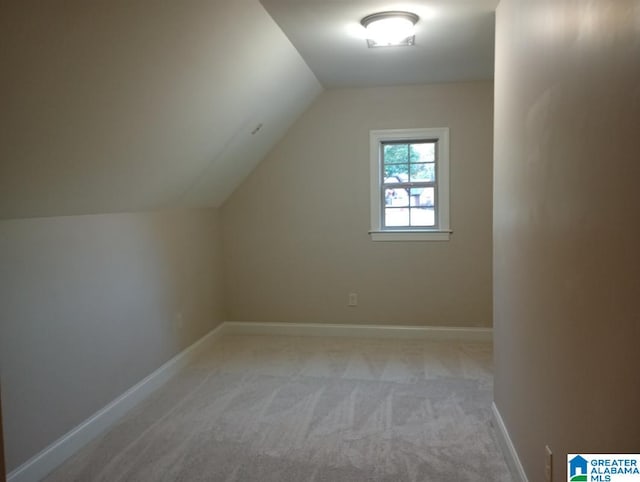 bonus room featuring lofted ceiling and light colored carpet