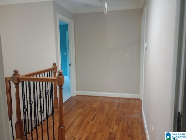 hallway featuring ornamental molding and light hardwood / wood-style floors