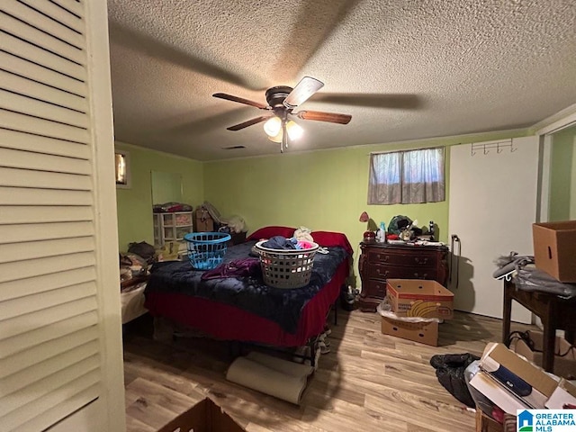 bedroom with light hardwood / wood-style floors, a textured ceiling, and ceiling fan