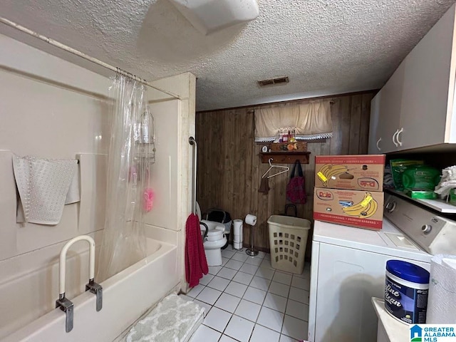 bathroom with wood walls, shower / tub combo, a textured ceiling, tile patterned floors, and washer and clothes dryer