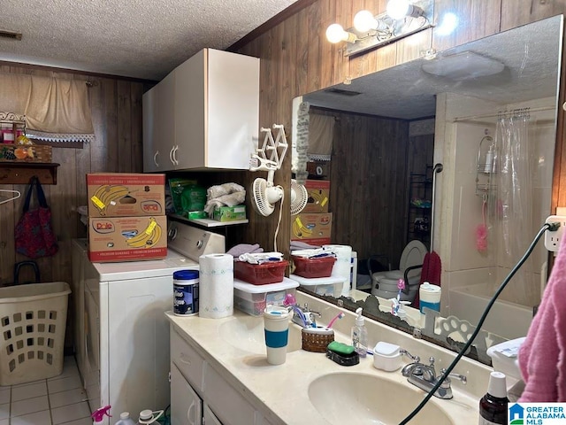 bathroom featuring wood walls, a textured ceiling, walk in shower, vanity, and tile patterned flooring