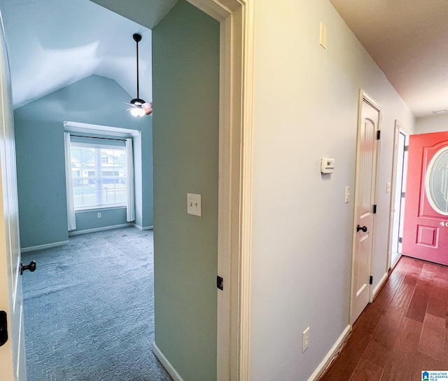 hall featuring lofted ceiling and hardwood / wood-style floors