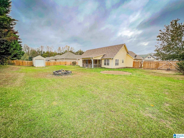 back of house with an outdoor fire pit, a lawn, and a sunroom