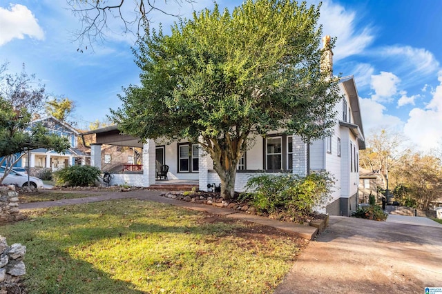 obstructed view of property with a front lawn