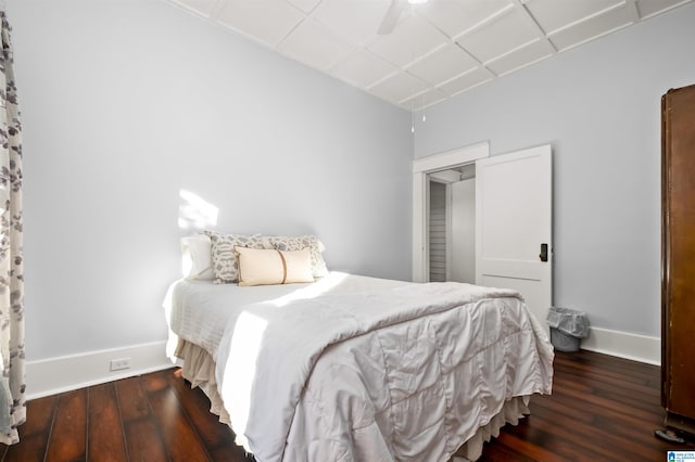 bedroom with dark wood-type flooring, ceiling fan, and a closet