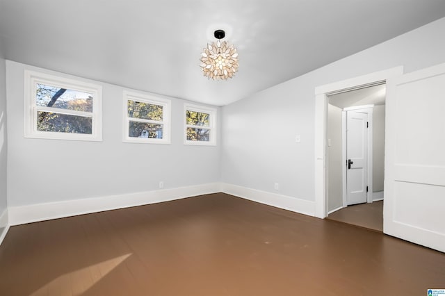 empty room featuring plenty of natural light and vaulted ceiling