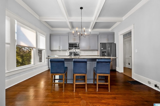 kitchen with gray cabinets, dark wood-type flooring, appliances with stainless steel finishes, and a kitchen island with sink