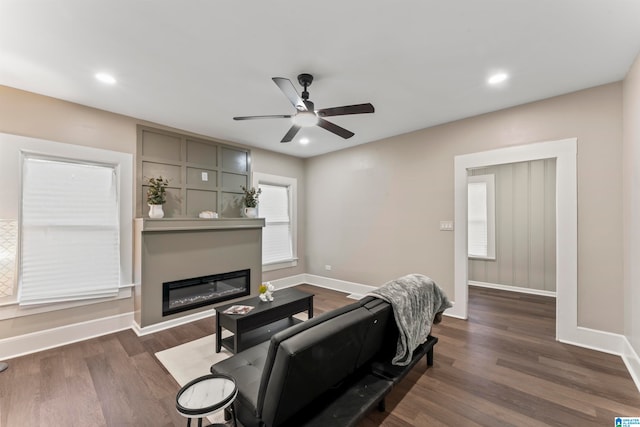 living room featuring dark wood-type flooring and ceiling fan