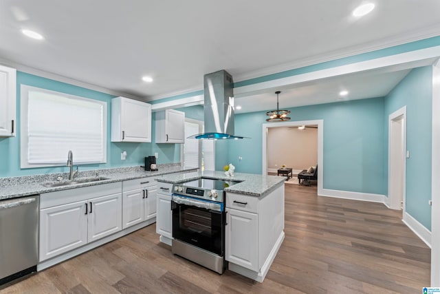 kitchen featuring island exhaust hood, white cabinets, light hardwood / wood-style flooring, decorative light fixtures, and stainless steel appliances