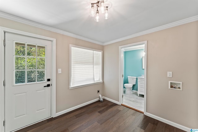 entryway with crown molding, dark hardwood / wood-style floors, and a chandelier