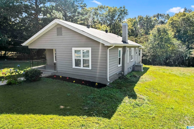 view of side of home featuring central AC and a lawn