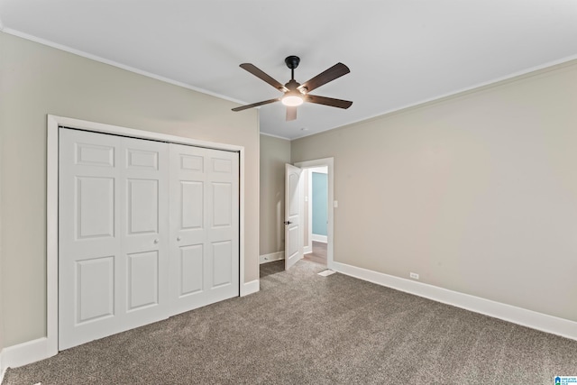 unfurnished bedroom with a closet, ceiling fan, crown molding, and carpet floors