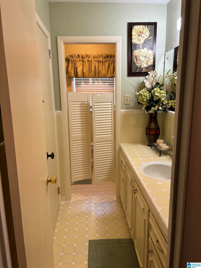 bathroom with vanity and tile walls