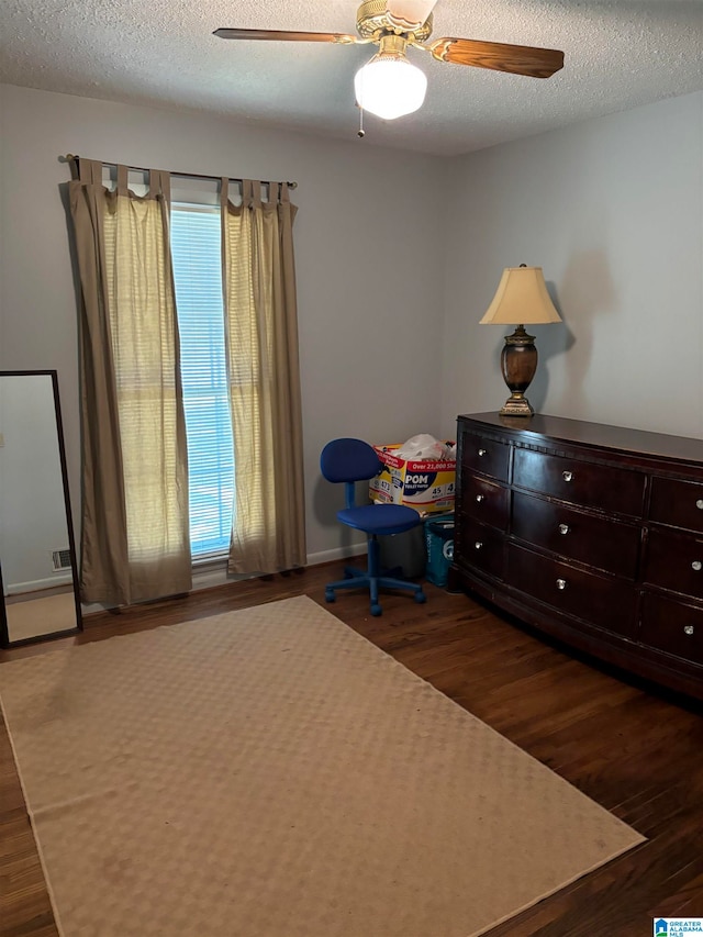 unfurnished bedroom with ceiling fan, a textured ceiling, and dark hardwood / wood-style flooring