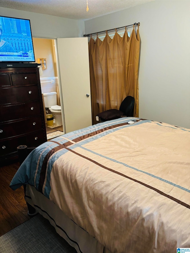 bedroom featuring a textured ceiling, ensuite bath, and wood-type flooring