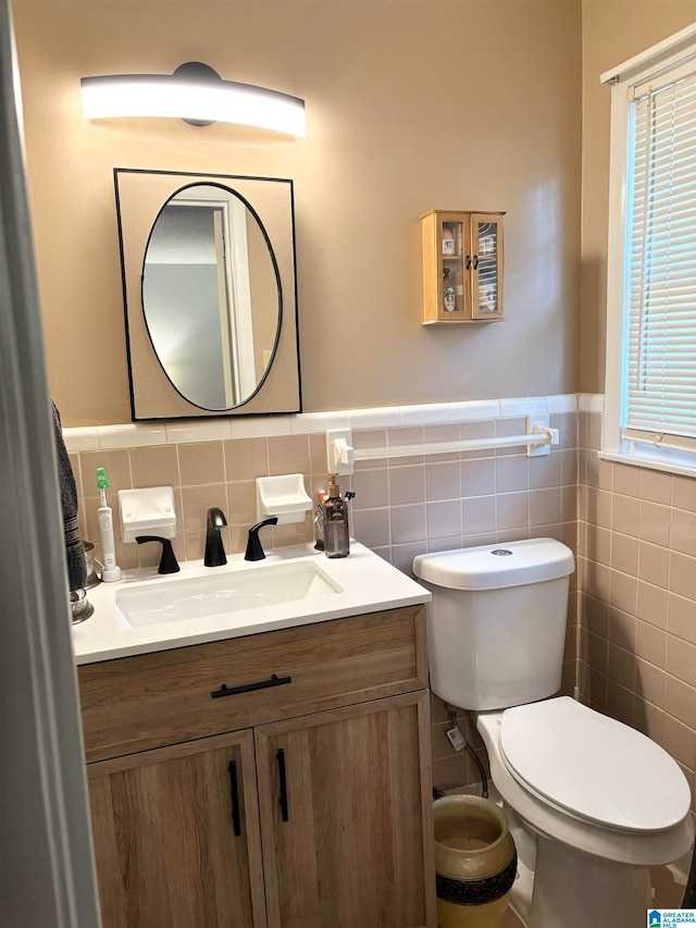 bathroom featuring vanity, toilet, and tile walls