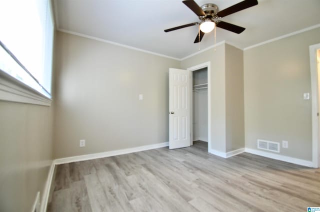 unfurnished bedroom featuring light hardwood / wood-style floors, crown molding, a closet, and ceiling fan