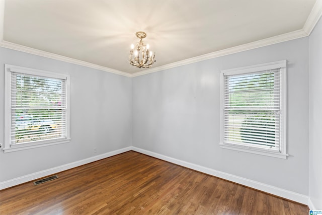 empty room with dark hardwood / wood-style flooring, a notable chandelier, and crown molding