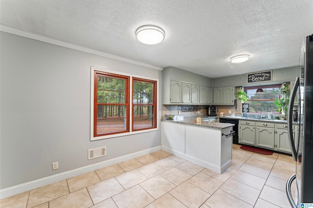 kitchen featuring kitchen peninsula, a healthy amount of sunlight, and light tile patterned flooring