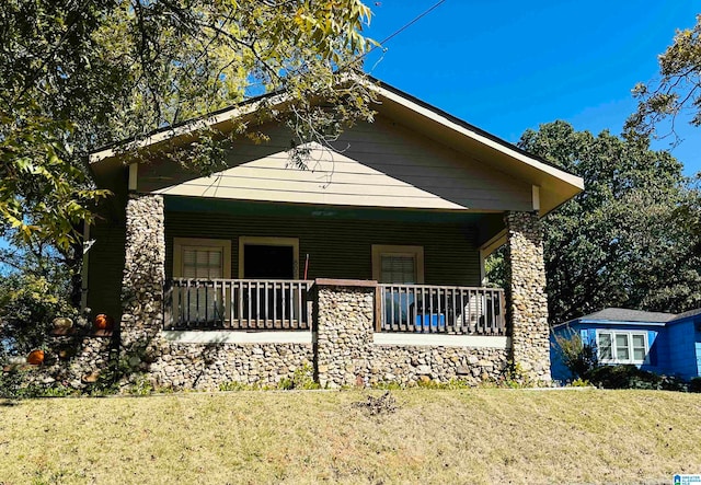 view of front of home with a porch and a front lawn