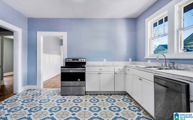 kitchen with light wood-type flooring, appliances with stainless steel finishes, sink, and white cabinets