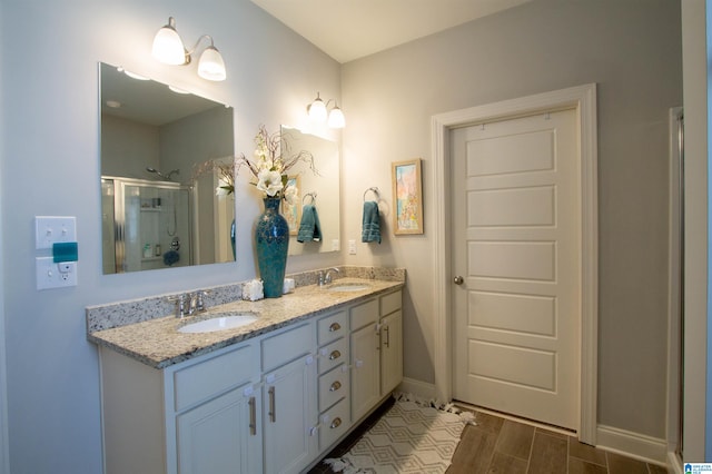 bathroom with vanity, a shower with shower door, and wood-type flooring