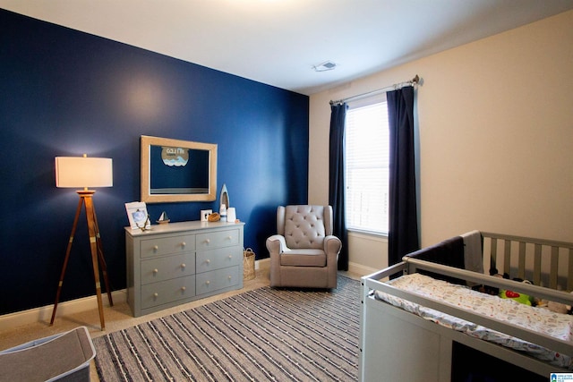 bedroom with light carpet and a crib