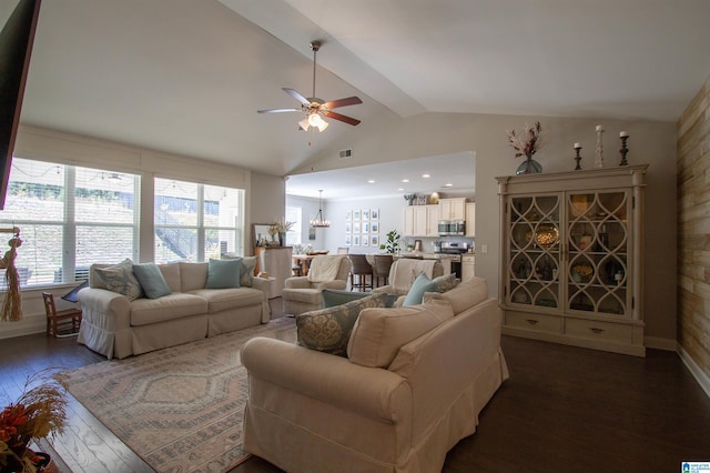 living room featuring dark hardwood / wood-style floors, ceiling fan with notable chandelier, and vaulted ceiling