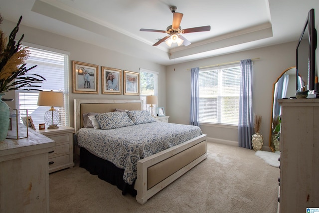 bedroom featuring light carpet, ceiling fan, and a raised ceiling