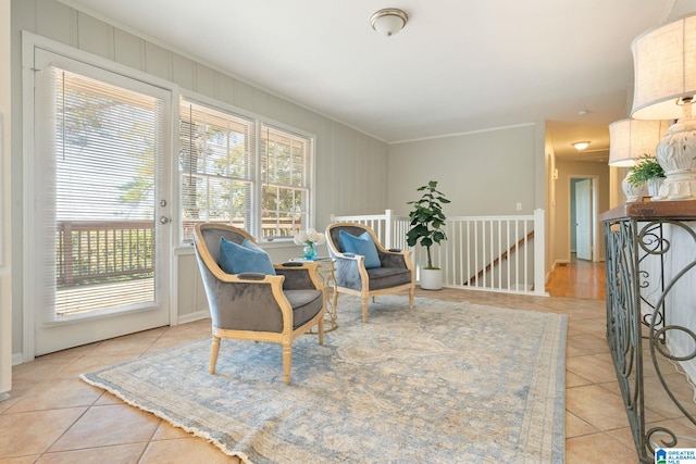 living area with a wealth of natural light, crown molding, and light tile patterned floors