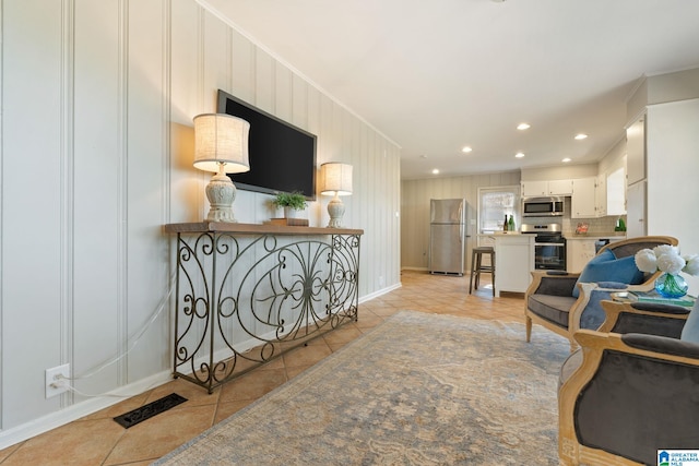 living room with crown molding and light tile patterned flooring