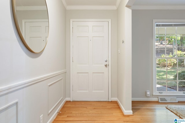 doorway featuring light hardwood / wood-style floors, ornamental molding, and plenty of natural light