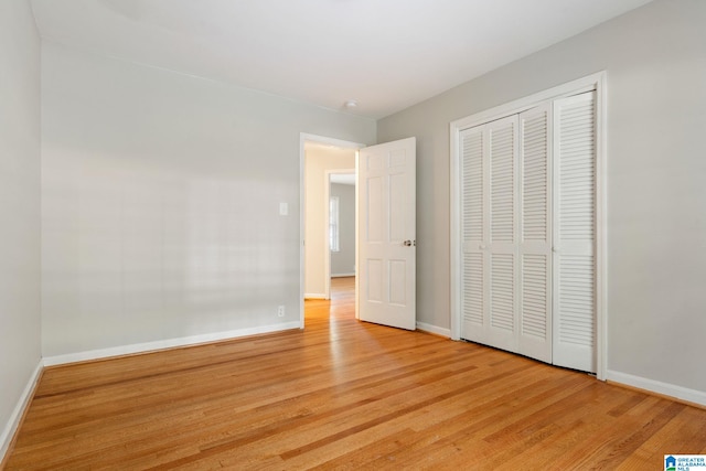 unfurnished bedroom with a closet and light hardwood / wood-style floors