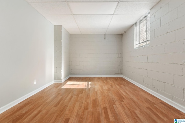 unfurnished room with a paneled ceiling and light wood-type flooring