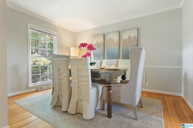 dining space featuring ornamental molding and wood-type flooring