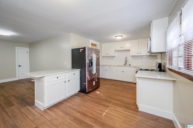 kitchen featuring white cabinets, stainless steel appliances, wood-type flooring, and sink