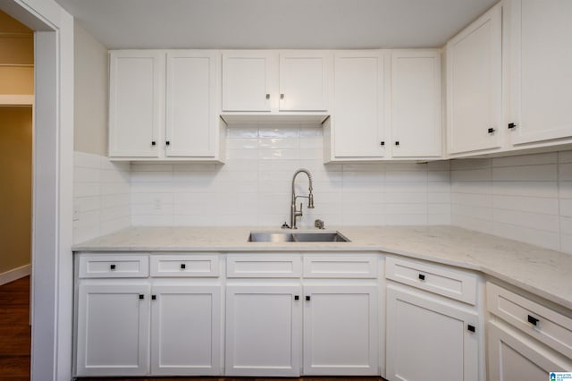 kitchen with backsplash, sink, and white cabinets