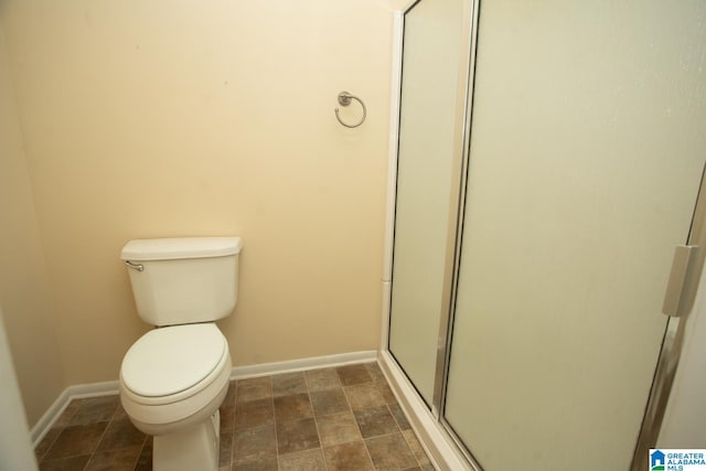 bathroom with a shower with door and toilet