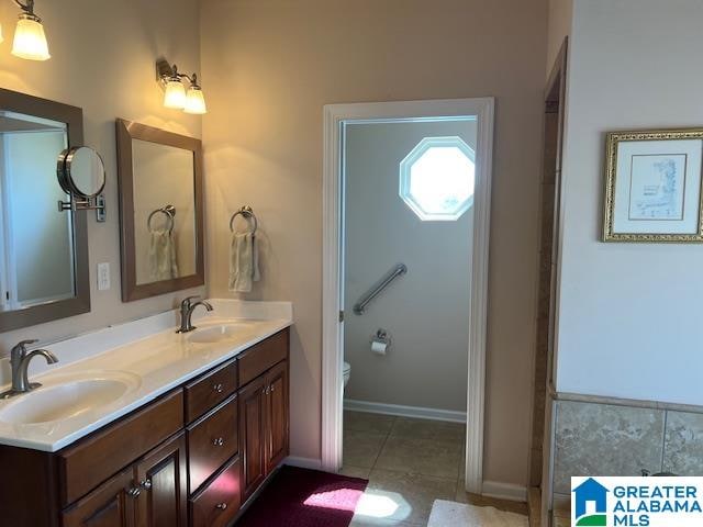 bathroom featuring vanity, toilet, and tile patterned flooring