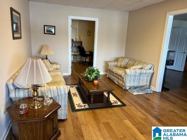 living room with a paneled ceiling and hardwood / wood-style flooring