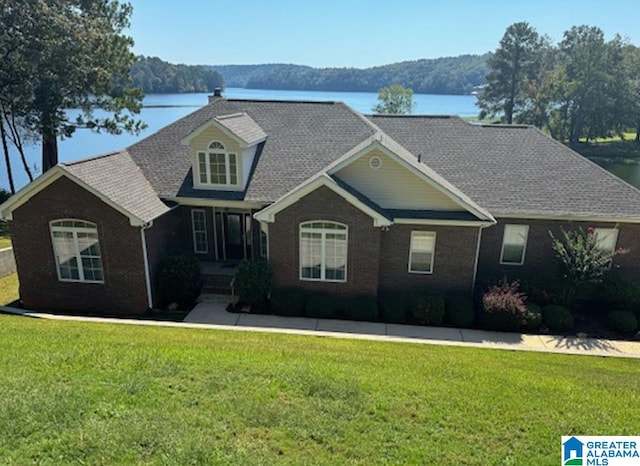 view of front of house featuring a front lawn and a water view