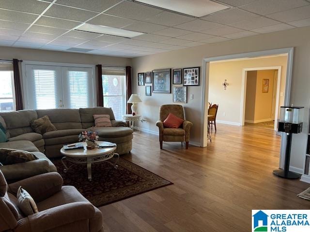 living room featuring a paneled ceiling and wood-type flooring