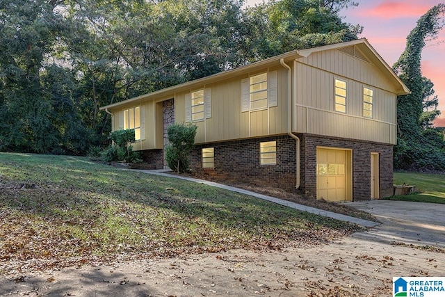 view of front of home with a garage and a lawn