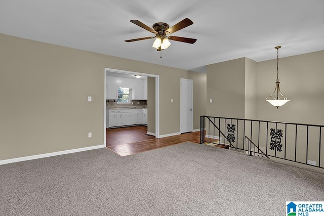 empty room with dark wood-type flooring and ceiling fan