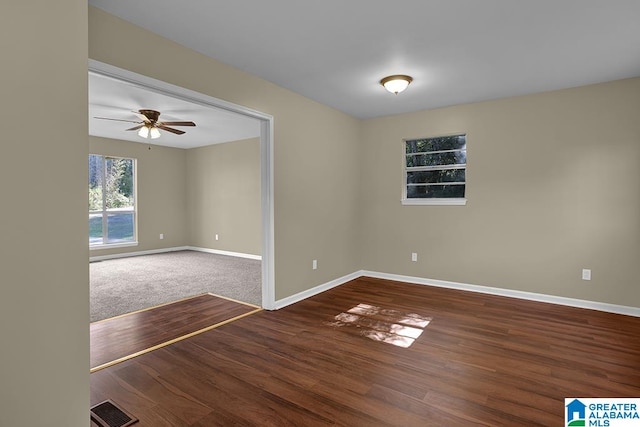 unfurnished room with ceiling fan and dark hardwood / wood-style flooring